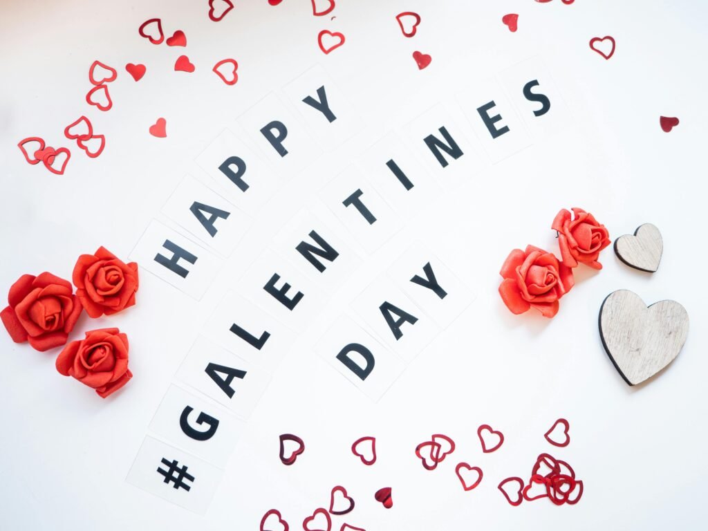 Happy Galentine's Day decor with red roses and hearts on white background.